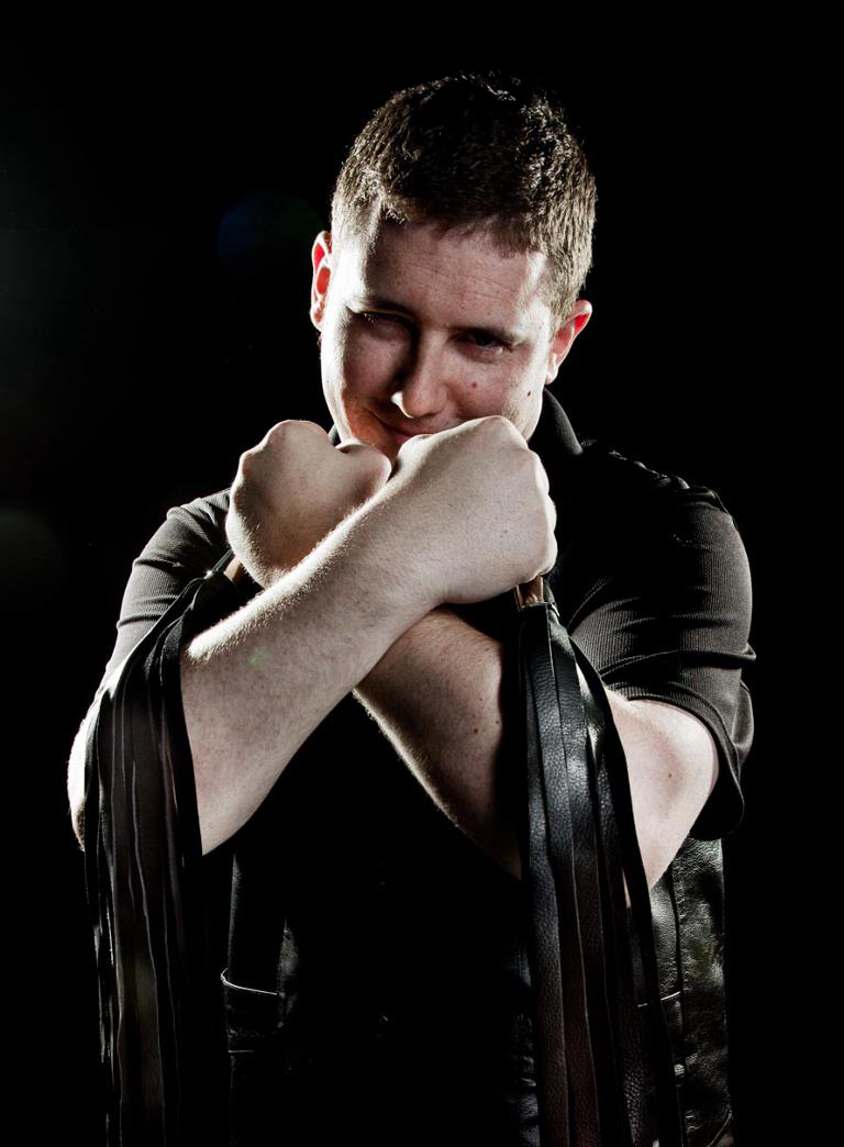 Jake crossing arms holding floggers